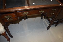 A 19th Century mahogany desk having skiver top, brass drop handles and turned legs