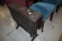 A Victorian dark stained gateleg occasional table having carved decoration