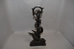 A Victorian cast iron door stop or porter in the design of a dragon wrapped around foliage