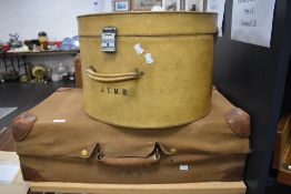 Three pieces of early 20th century luggage including large hat box, and suitcases with protective