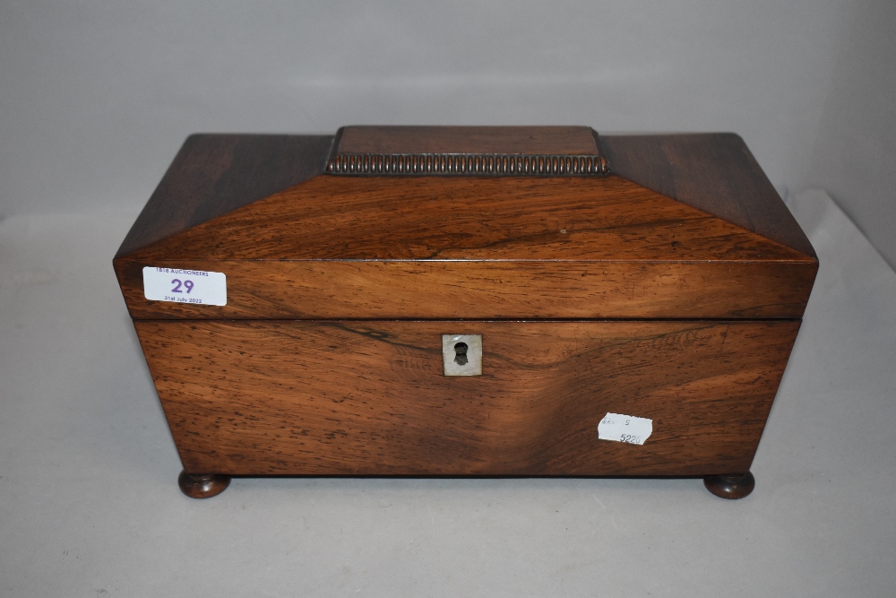 A Victorian rosewood casket form tea caddy on bun feet