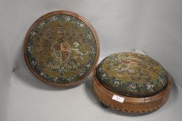 A pair of Victorian button form foot stools with beaded worked tops in family crest or cypher