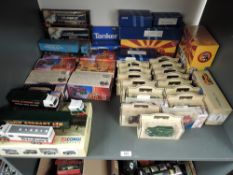 A shelf containing 18 various scale Machbox, Maisto and similar diecast trucks and 19 Lledo Days