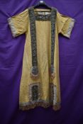 A gold and blue costume having heavily beaded panels edged with braiding to front of costume and