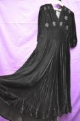 A late 1940s black velvet evening gown with bead detailing and half belt to waist,side metal