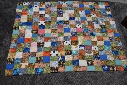 A small vintage patchwork quilt using predominantly 1950s fabrics sold with a piece of art deco