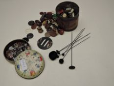 A selection of long hat pins, two possibly jet, and two tins of vintage buttons and buckles.