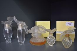 A collection of Nina Ricci perfume bottles, one having partial contents and the others empty, one