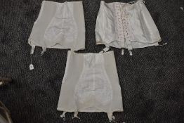 Three vintage girdles, two having zip fastenings and one with hook and eye.