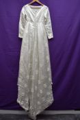 A 1960s wedding dress having long train and crotchet floral motif details throughout,bracelet length