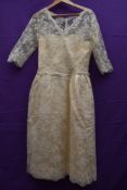 A late 1950s cream lace wedding dress having illusion strapless under dress with tulle lace