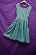 A 1950s green cotton full skirted day dress having ric rac edging, button front and slightly dropped