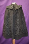 A stunning Victorian fully lined black wool cape, having intricate silk cut work overlay detail