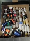 A box full of vintage reels of cotton thread, predominantly French.