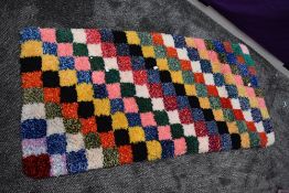 A hearth rug using bright strands of wool.