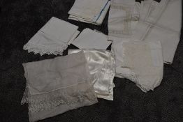 An assortment of antique linen, including damask table cloths and bed sheet, and deep crotchet edged