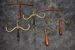 Five 19th century wood and brass barristers wig and cloak hangers, and another similar hanger.