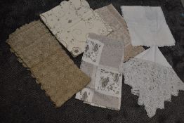 A mixed collection of table coverings, including extensively embroidered lawn cotton,crotchet and