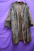 A vintage mid length fur coat in dark brown having wide cuffs.