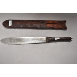 An early 20th century tribal or safari style machete knife with basic leather scabbard