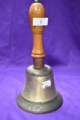 A vintage wooden handled ARP hand bell, body appears to have been polished, possibly to remove an