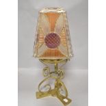 A Victorian Arts and Crafts oil lamp stand in brass with pressed glass shade in orange and purple
