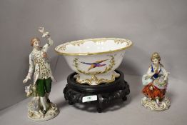 Two early 20th century classical figurines, one of lady, seated with rose in hand and hat perched on