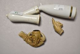 Two antique carved bone pipe bowls and a ceramic pipe with holder.