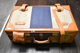 A vintage style suitcase, tweed style and leather finish