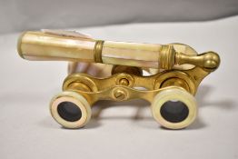 A set of 1920s/30s opera glasses of brass and mother of pearl having hinged handle and wheel