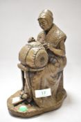 A composite figurine depicting a lady at work.