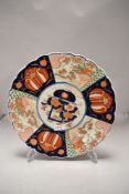 An antique Japanese porcelain plate in an Imari palette with traditional design