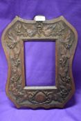 A large carved mahogany Arts and Crafts style frame (devoid of glass) having ivy design to border.