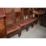 A set of four period oak and leather chairs with brass stud work