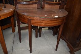 A Victorian Demi Lune fold over tea table in mahogany on fluted legs, with inlaid decoration to
