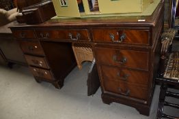 An antique mahogany key hole desk having green leather to top and three over six drawers.