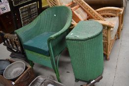 A painted green wicker Lloyd Loom style laundry basket and a basket chair/commode, dated 1950.