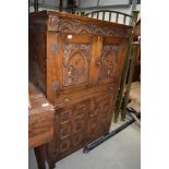 A 20th century cocktail drinks cabinet having oak frame with carved doors