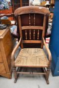 A late Victorian rocking chair having beech wood turned framed with strung seat