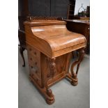 A Victorian walnut Davenport desk having intricate finial to top, piano lid, internal writing slope,