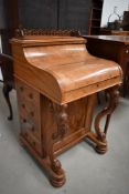 A Victorian walnut Davenport desk having intricate finial to top, piano lid, internal writing slope,