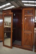 An early 20th century three part wardrobe with mirror centre door