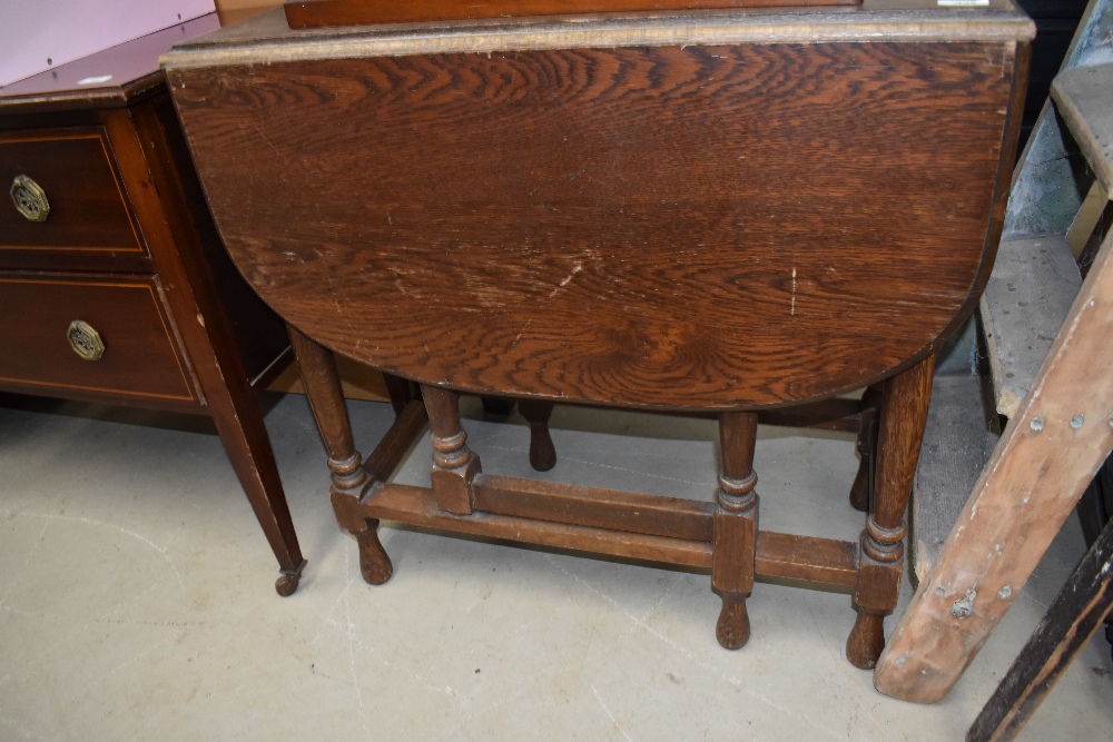 An early 20th century oak drop leaf gate leg dining table