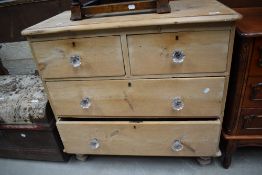 A late Victorian stripped pine chest of two over two drawers with glass handles