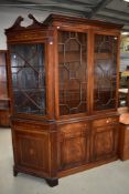 A 20th century reproduction library book case and cupboard having astral glazed doors, by Reprodux