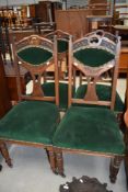 A set of four late 19th or early 20th Century oak dining chairs having green dralon upholstery