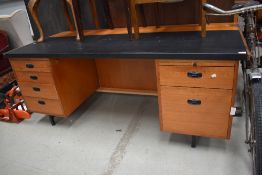 A large 1960s/70s desk having six drawers and a pen tray, vinyl clad to front portion.