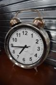 A 20th century over sized alarm clock with chrome finish