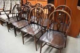 A set of eight (six plus two) dark stained Ercol dining chairs having fleur de lys style back