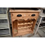 A modern pine kitchen storage unit with wine rack and under drawer